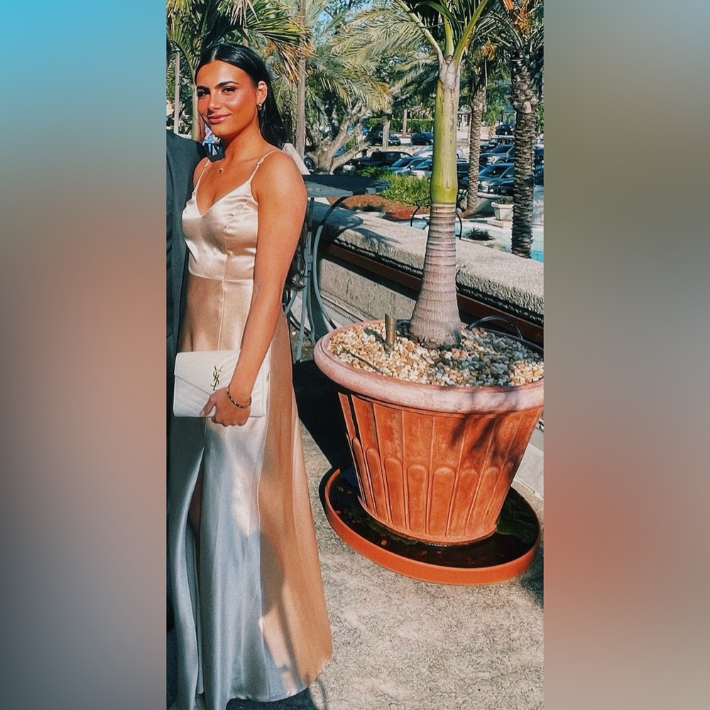 Floor length gold/champagne colored dress with leg slit on left side.